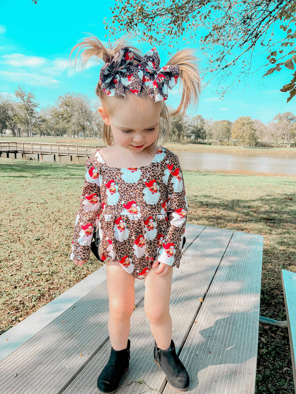 Leopard Santa ruffle romper for babies, festive holiday clothing, cute and stylish infant apparel.