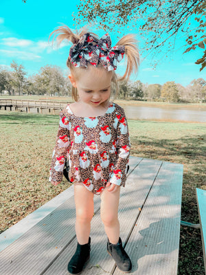 Leopard Santa ruffle romper for babies, featuring festive design and playful ruffles, angle view.