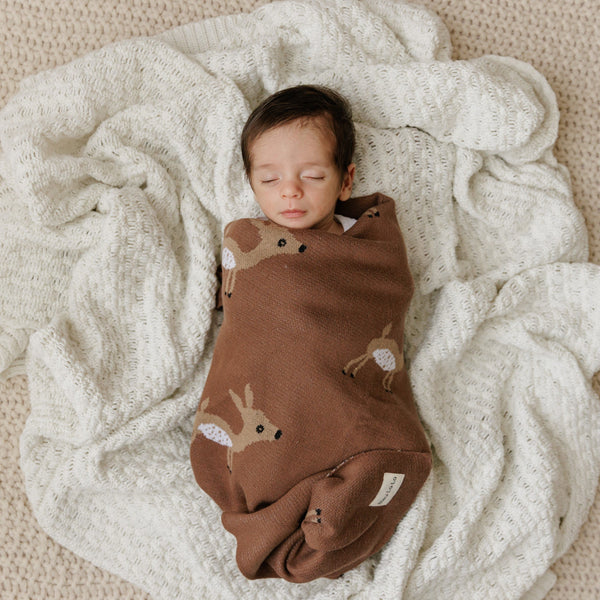 Luxury cotton deer knit swaddle baby blanket in angle view, perfect for cozying up your little one.