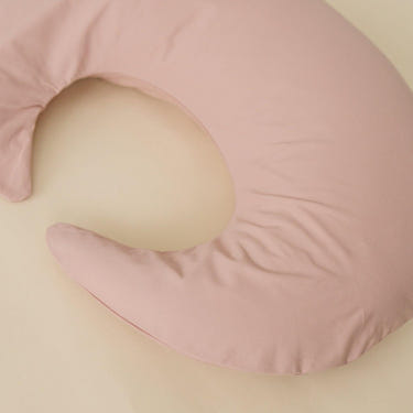 Blush nursing pillow cover for comfortable breastfeeding support, perfect for new moms.