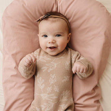 Blush infant lounger cover for babies, perfect accessory for comfort and style.
