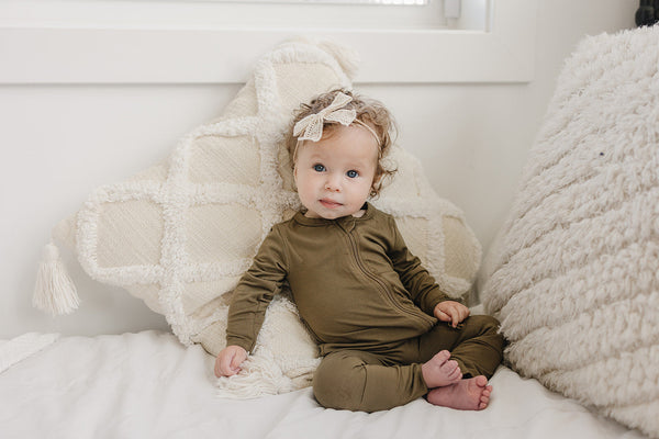 Solid Bamboo Zippy Pajamas in various colors, angle view showcasing soft fabric and zip design for babies.