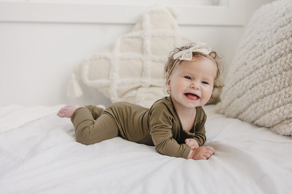 Solid Bamboo Zippy Pajamas in various colors, angle view showcasing soft, cozy fabric for babies.