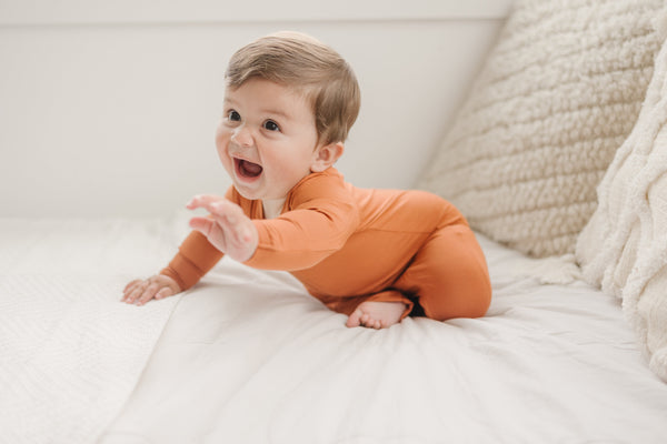 Solid Bamboo Zippy Pajamas in various colors, angle view showcasing soft fabric and zip design for baby comfort.