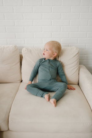Solid Bamboo Zippy Pajamas in various colors, angle view showcasing soft, comfy fabric for babies.
