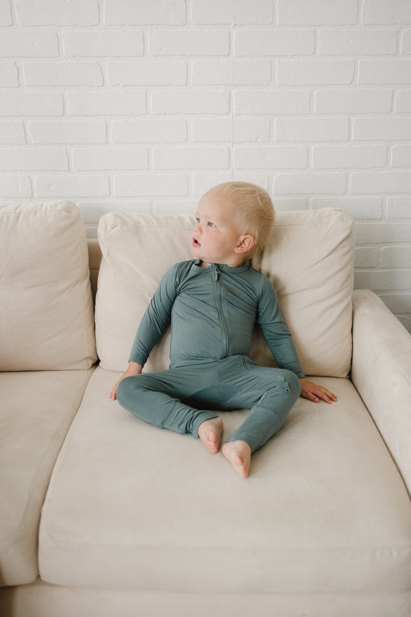 Solid Bamboo Zippy Pajamas in various colors, angle view showcasing soft, comfy fabric for babies.