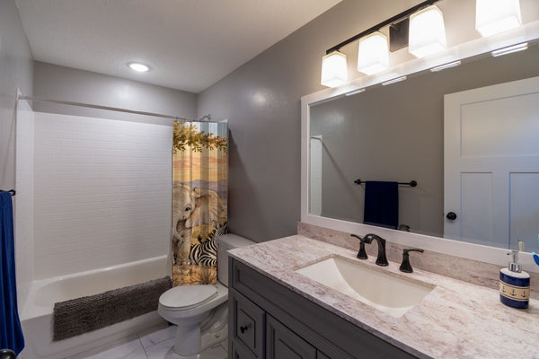 Sunset Savanna shower curtain pulled open in a gray kids bathroom