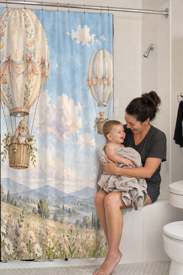 Mom holding her baby on the tub edge next to the Meadow Hot Air Balloons shower curtain