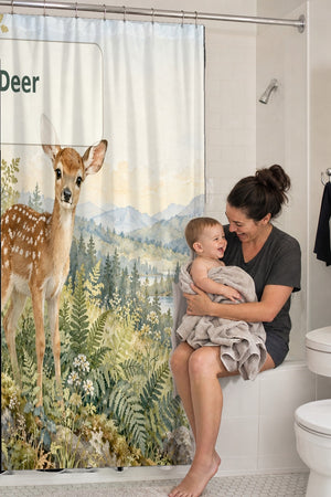 Mom holding her baby on the tub edge next to the D is for Deer Alphabet shower curtain