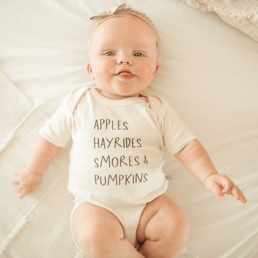 Short sleeve graphic bodysuit featuring apples, hayrides, and s'mores design for babies.