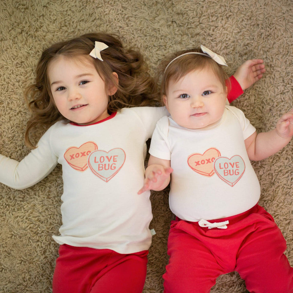 Short sleeve baby bodysuit featuring a cute candy hearts graphic design. Perfect for little ones!