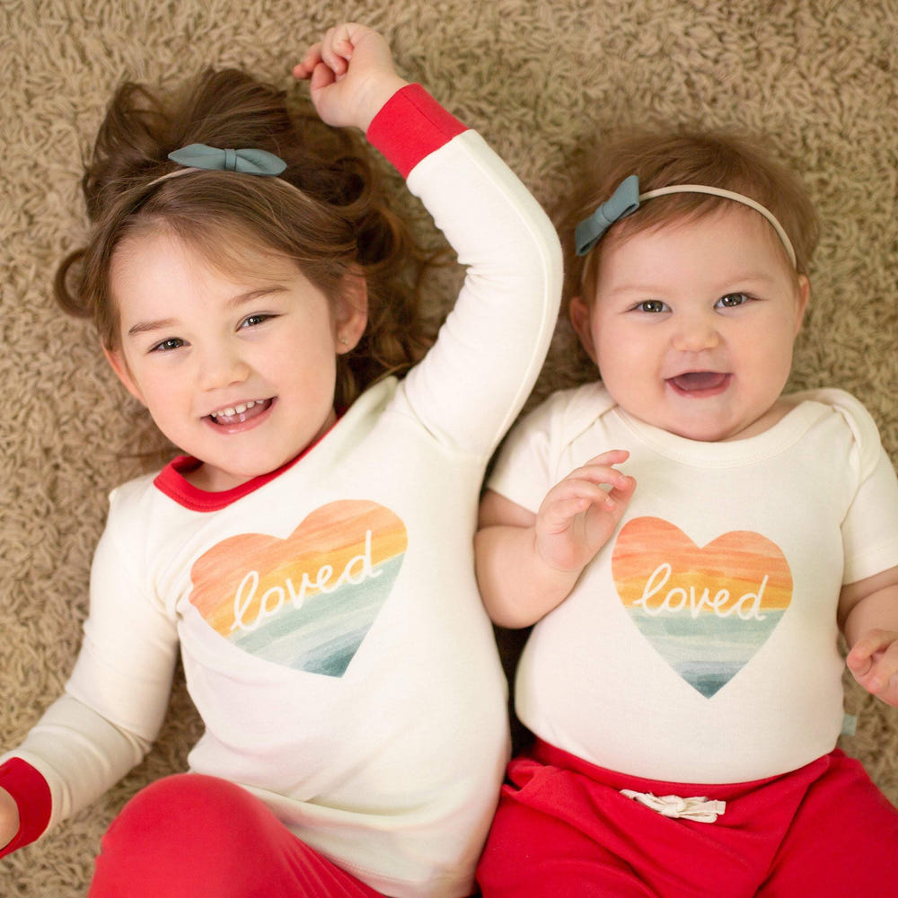 Short sleeve graphic bodysuit featuring a loved rainbow heart design for babies.