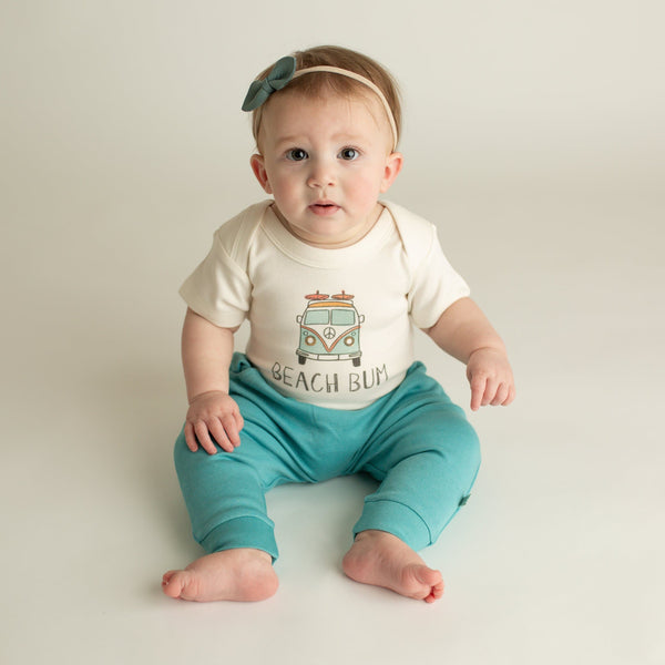 "Graphic short sleeve bodysuit for babies featuring 'Beach Bum' design, angle view showcasing style and comfort."