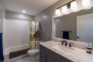 Animal Music Festival shower curtain pulled open in a gray kids bathroom