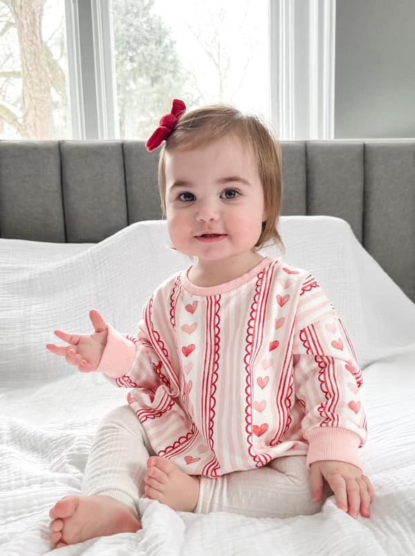 Laced with Love Sweatshirt Romper for babies in soft fabric, perfect for stylish comfort and playtime.