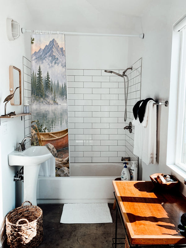 Canoe Lake Camping shower curtain hanging on the rod over a white bathtub