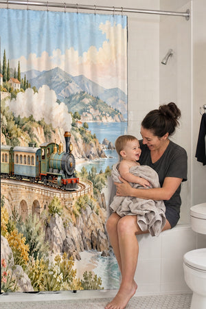 Mom holding her baby on the tub edge next to the Coastal Train shower curtain