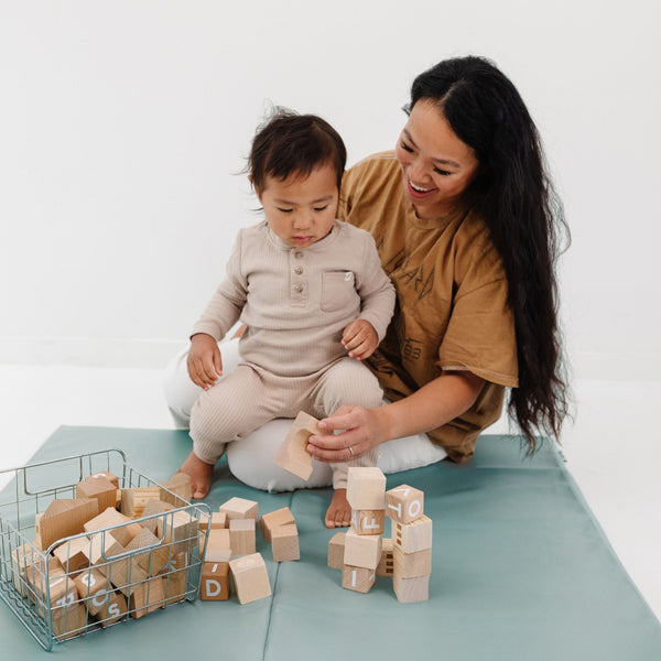 Sage Vegan Leather Play Mat at an angle, perfect for stylish and safe baby playtime.