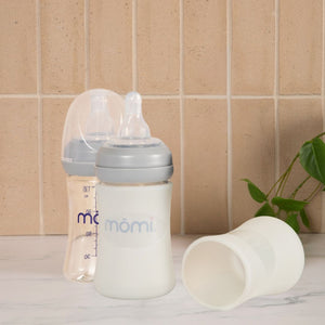 Mōmi silicone 4 oz glass bottle sleeves in various colors, showcasing angle 2 view for stylish baby bottle protection.