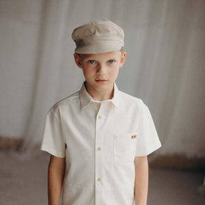 Beige peak cap for babies, stylish and comfortable, shown from angle 3.