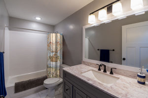 Meadow Hot Air Balloons shower curtain pulled open in a gray kids bathroom