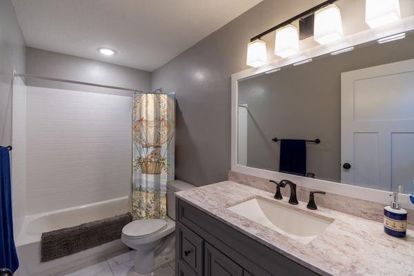 Meadow Hot Air Balloons shower curtain pulled open in a gray kids bathroom