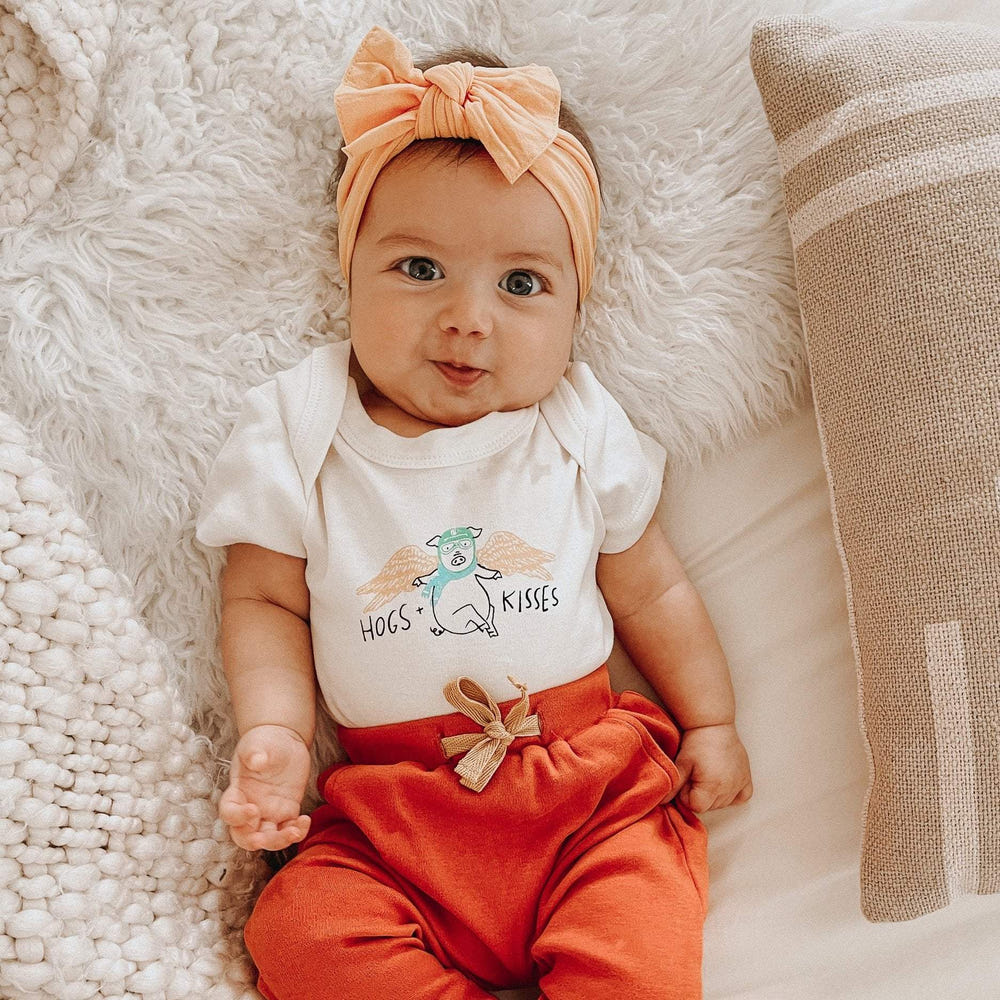 Graphic bodysuit "Hogs and Kisses" for babies, featuring a cute design and short sleeves. Perfect for playful outfits.