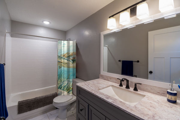Sea Turtles Ocean shower curtain pulled open in a gray kids bathroom