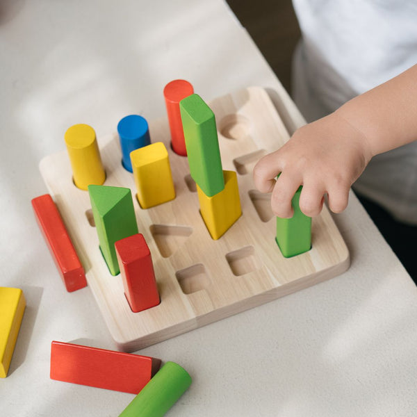 Colorful geometric peg board for babies, promoting early learning and sensory play at an engaging angle.