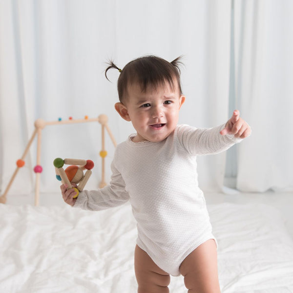 Colorful triangle clutching toy for babies, promoting sensory play and motor skills development. Angle 5 view.