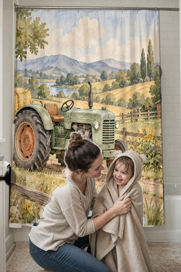 Mom drying her toddler in a hooded towel in front of the Farm Tractor shower curtain