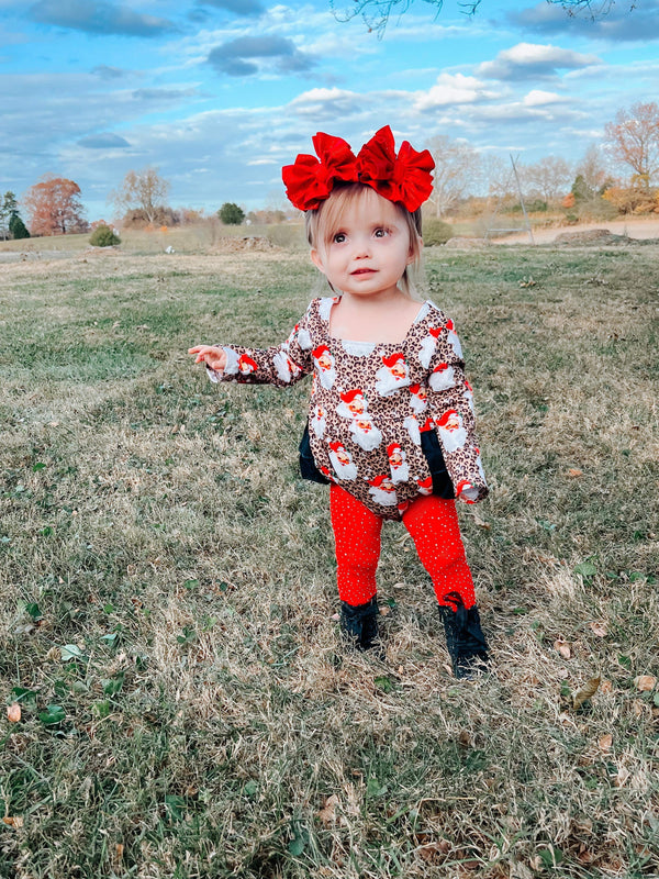 Leopard Santa ruffle romper for babies, festive holiday outfit, stylish and cute, angle view.