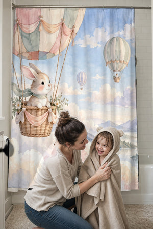 Mom drying her toddler in a hooded towel in front of the Bunny Hot Air Balloon shower curtain