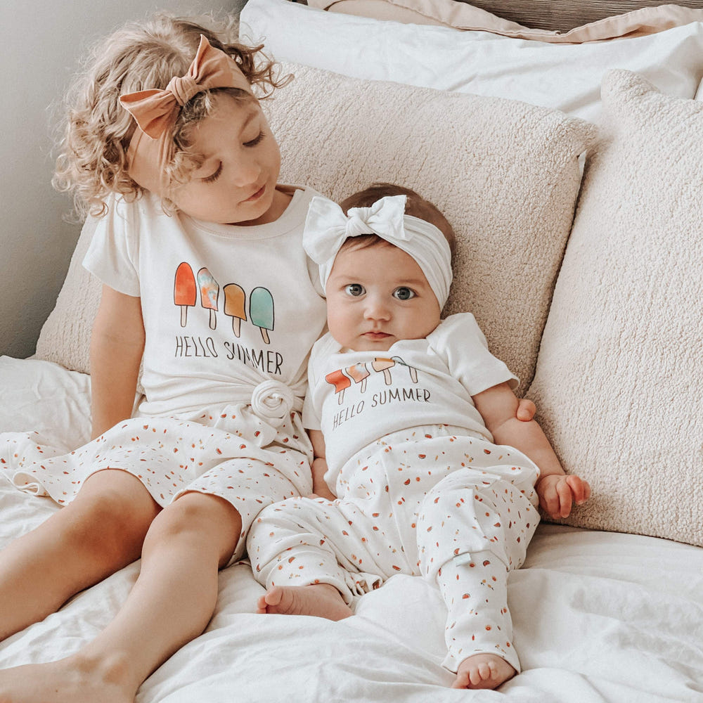 Graphic bodysuit for babies featuring "Hello Summer" design, perfect for warm weather. Short sleeve style.