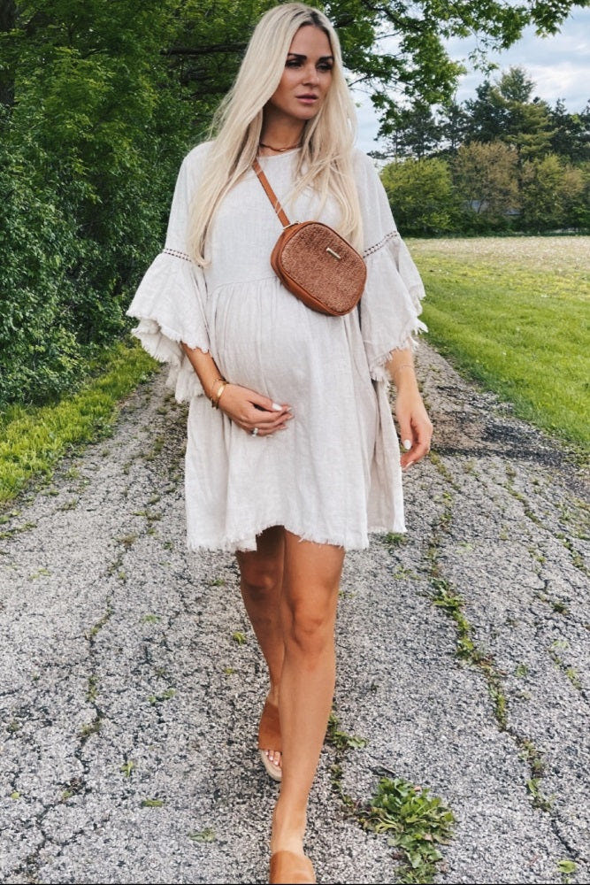 Beige raw edge bell sleeve babydoll maternity dress for stylish and comfortable pregnancy wear.