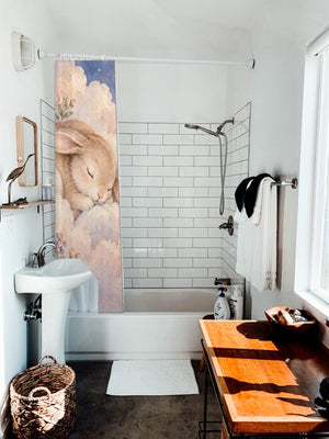 Cloud Bunny shower curtain hanging on the rod over a white bathtub