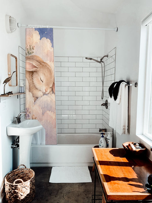Cloud Bunny shower curtain hanging on the rod over a white bathtub