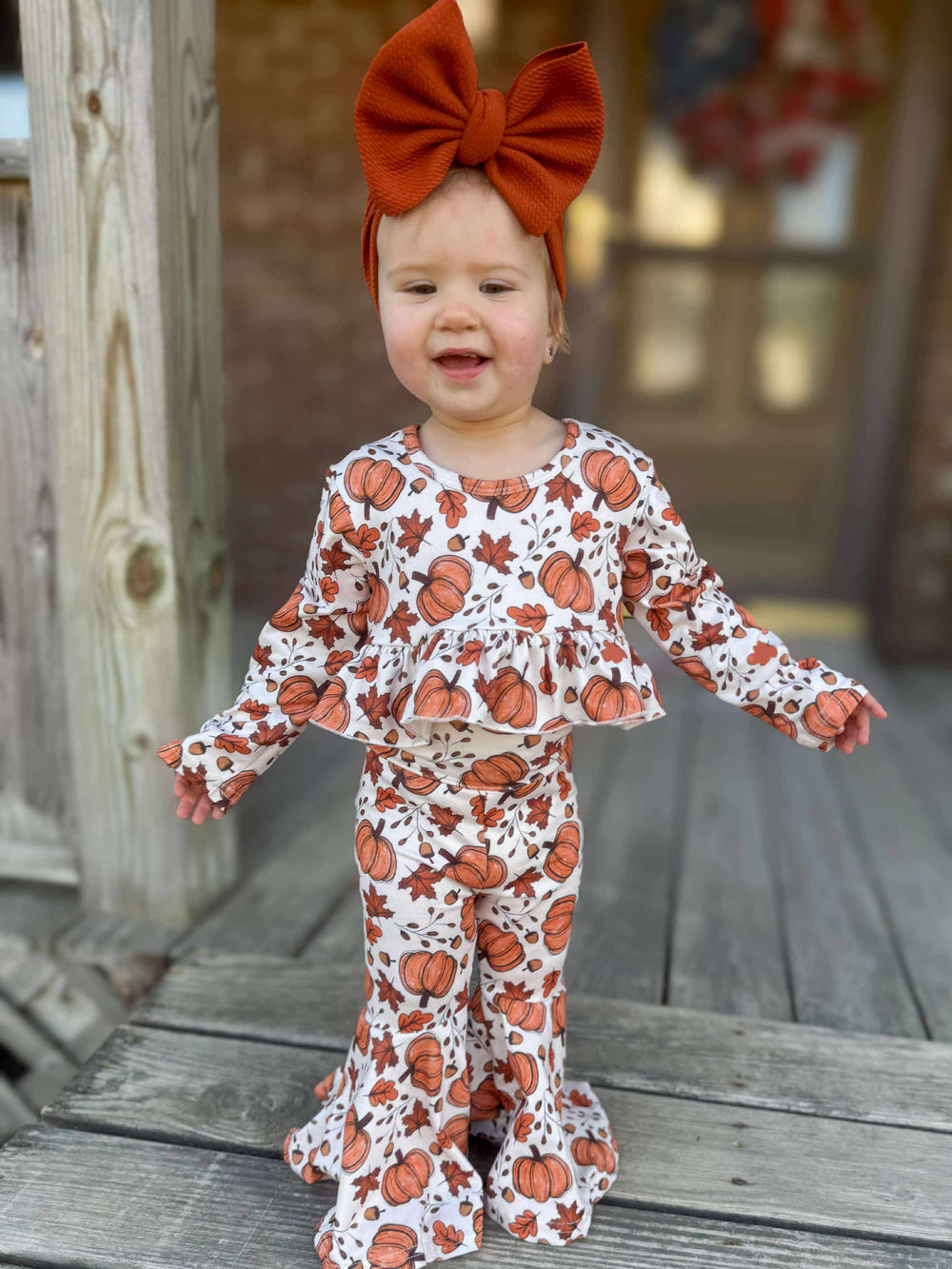 High-waisted ruffle bell set with pumpkin and leaves design for babies, perfect for playtime and fall festivities.
