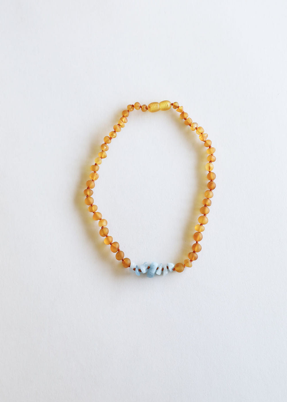 Raw honey Baltic amber and aquamarine baby necklace for teething relief and style.