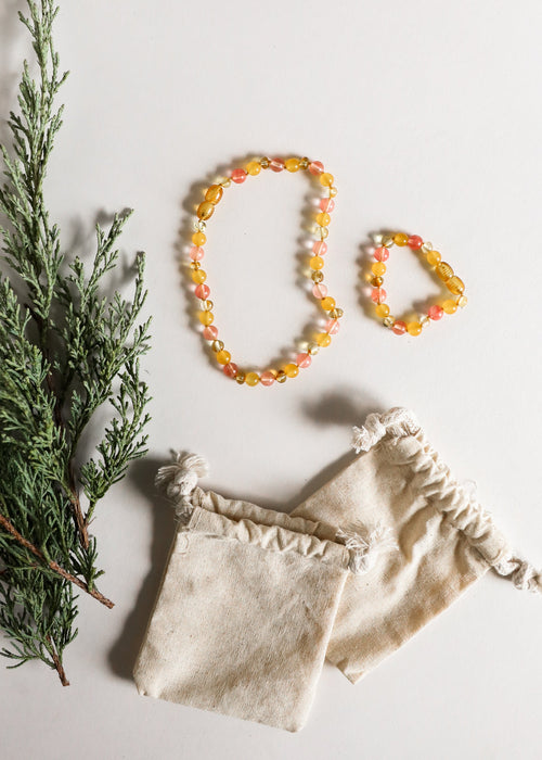 Polished honey Baltic amber and honeysuckle gemstone necklace for kids, perfect for teething and stylish wear.