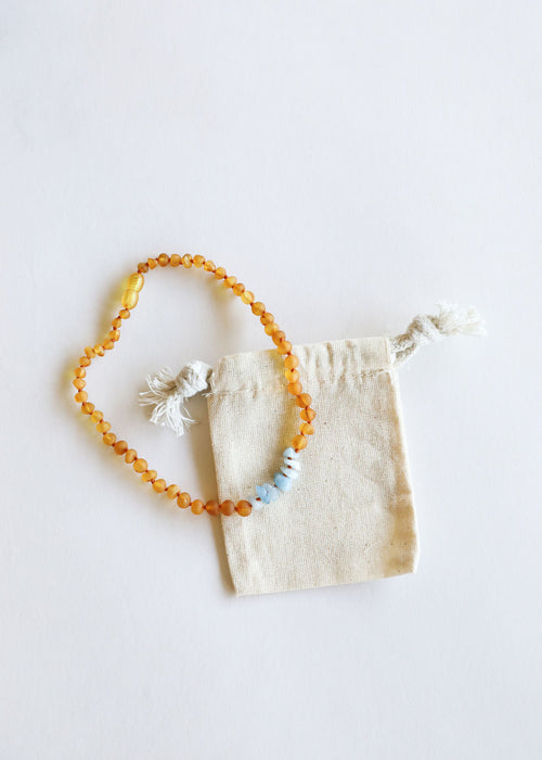 Raw honey Baltic amber and aquamarine baby necklace, angle view 6, perfect for teething relief and style.