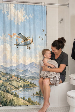 Mom holding her baby on the tub edge next to the Balloon and Plane shower curtain