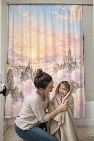 Mom drying her toddler in a hooded towel in front of the Cloud Towers Fairy Tale shower curtain