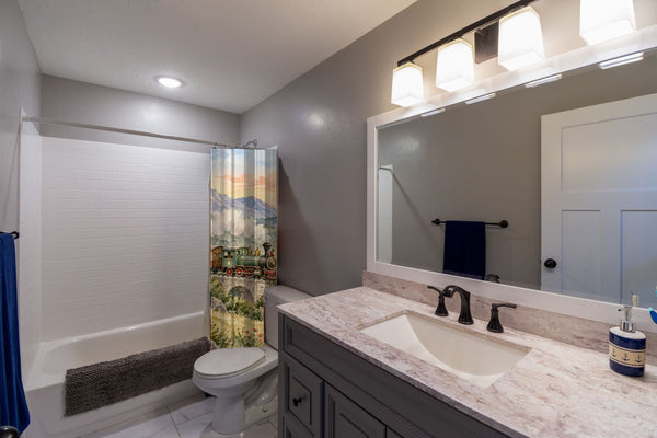 Sunrise Train shower curtain pulled open in a gray kids bathroom