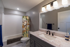 Koala Ukulele shower curtain pulled open in a gray kids bathroom
