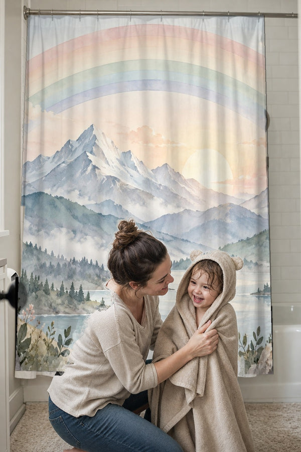 Mom drying her toddler in a hooded towel in front of the Sunrise Lake Rainbow shower curtain