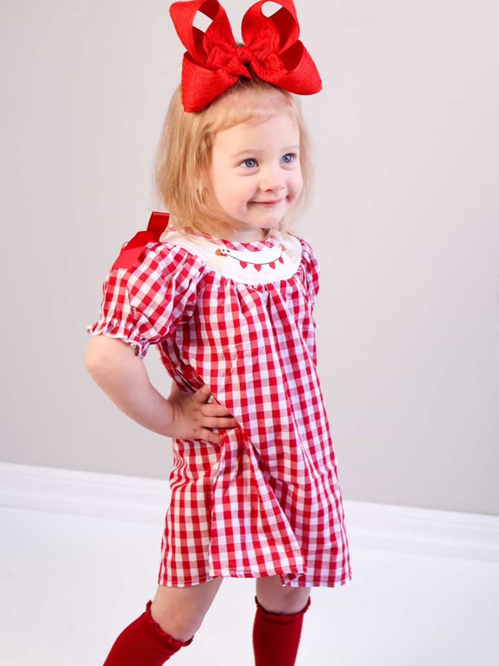 Valentine Red Plaid Dress with Smocked Heart Dog Detail and Bows for babies, perfect for festive occasions.