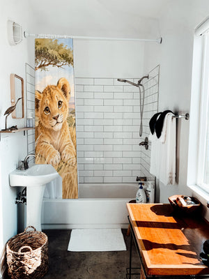 Lion Cub Safari shower curtain hanging on the rod over a white bathtub