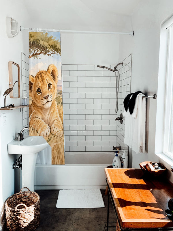Lion Cub Safari shower curtain hanging on the rod over a white bathtub