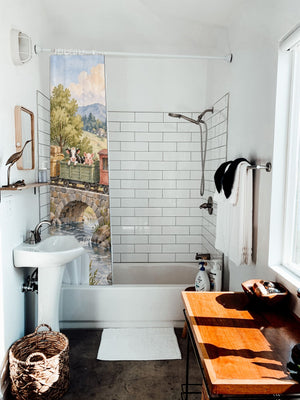 Countryside Train shower curtain hanging on the rod over a white bathtub